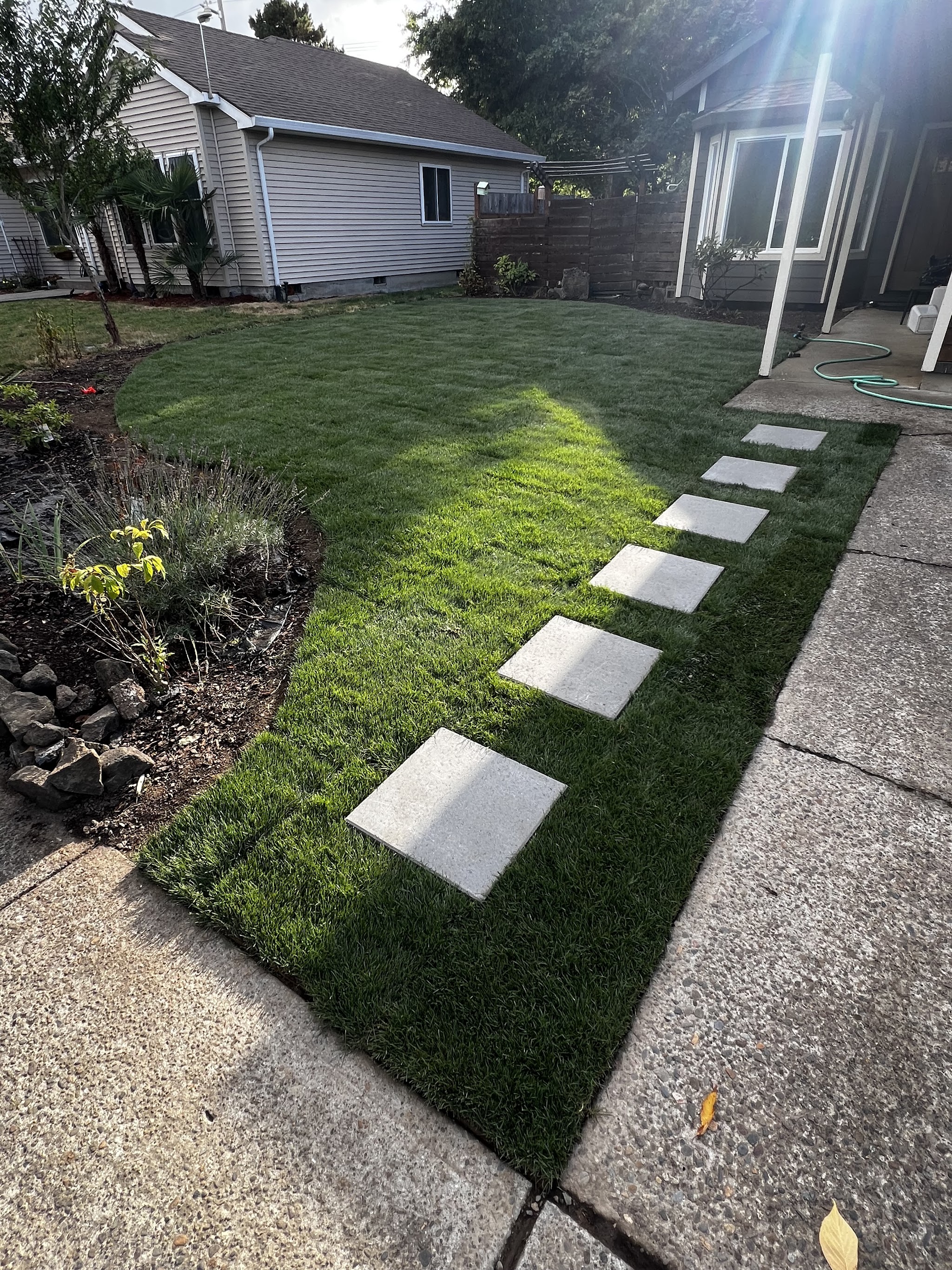 A stepping stone path laid through a newly sodded backyard lawn